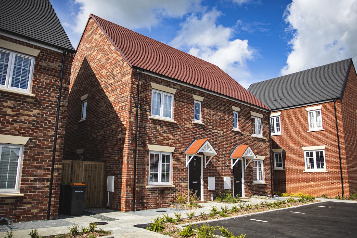 A red-brick suburban house with a small front garden, the sort of Greater Manchester home we survey.